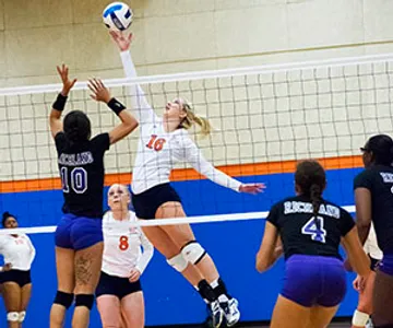 An Eastfield volleyball player spikes the ball over the net