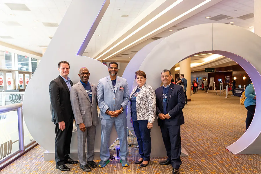 Campus presidents pose in front of 60th Anniversary sculpture.