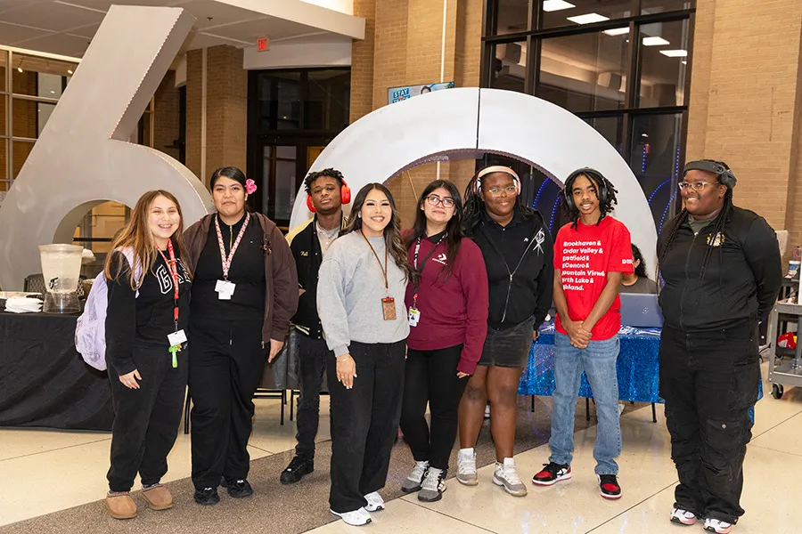 Group of seven students pose in front of 60th Anniversary sculpture.