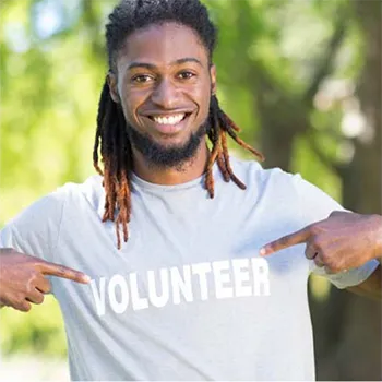 Alumni pointing to volunteer shirt