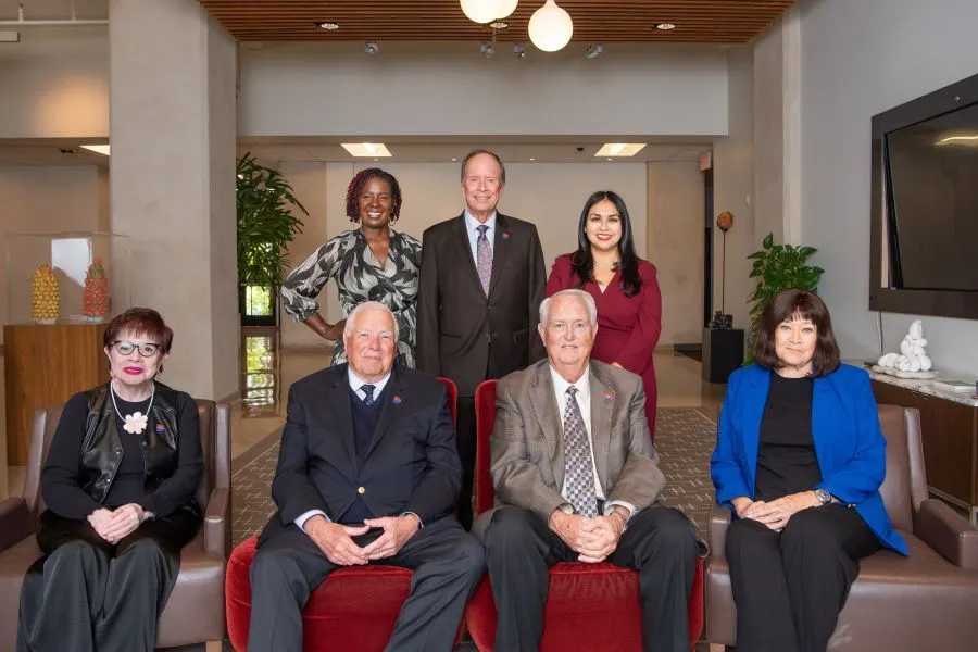 The board of trustees sit in the lobby of the college admin office
