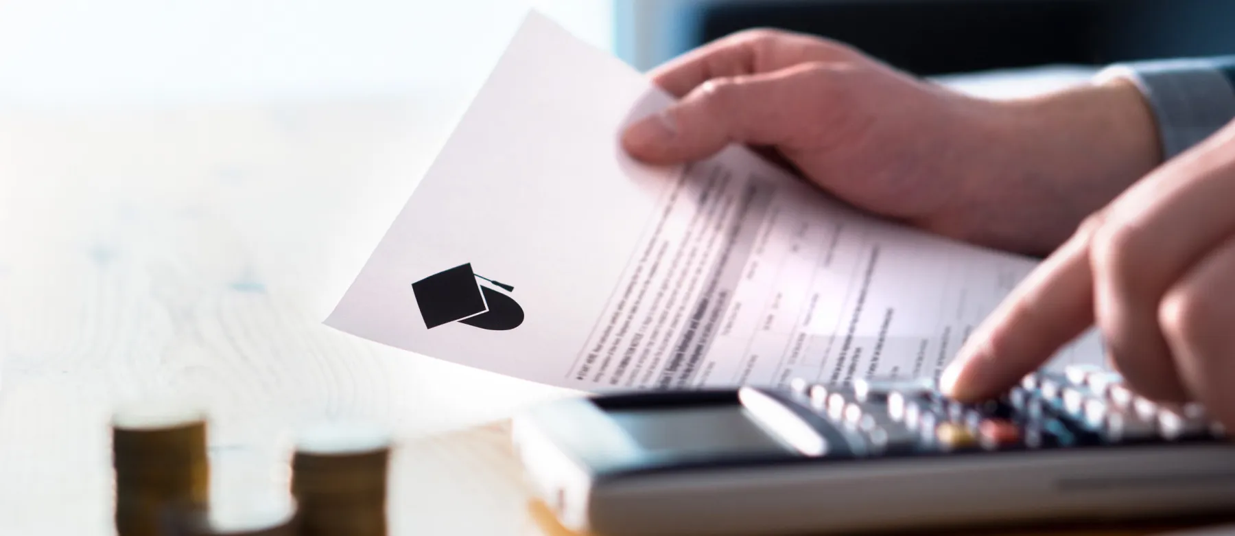 A student fills out form at a desk with a calculator nearby