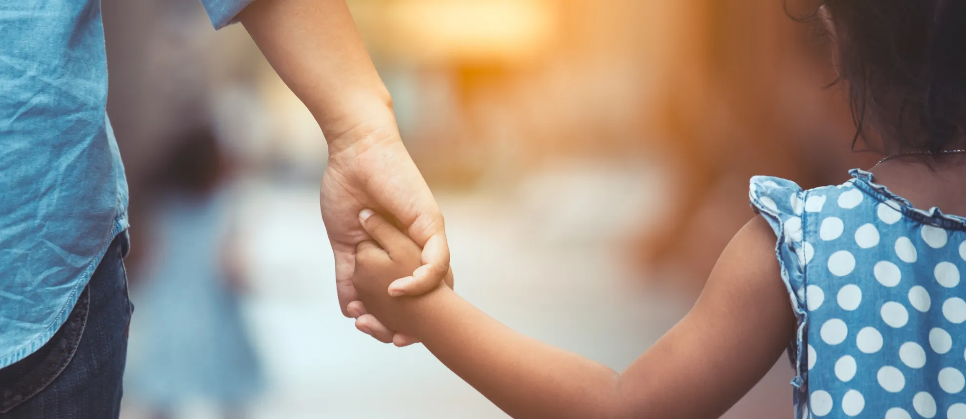 A daughter holds her father's hand