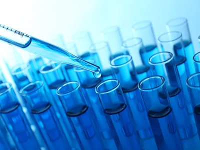 Laboratory pipette dispensing liquid into test tubes.