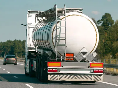 Tanker truck transporting liquid cargo on a roadway.