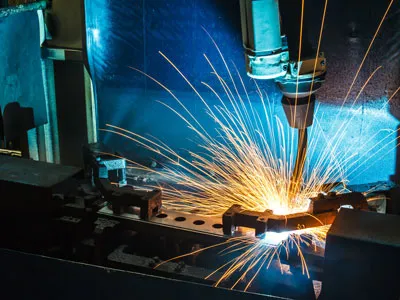 Industrial laser cutting machine shaping metal in a manufacturing facility.