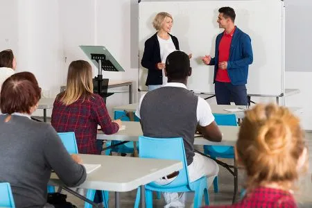 Students speaking with teacher in a classroom