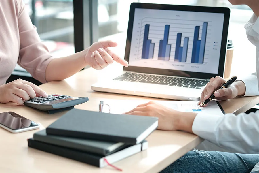 People sitting at a computer displaying bar charts.