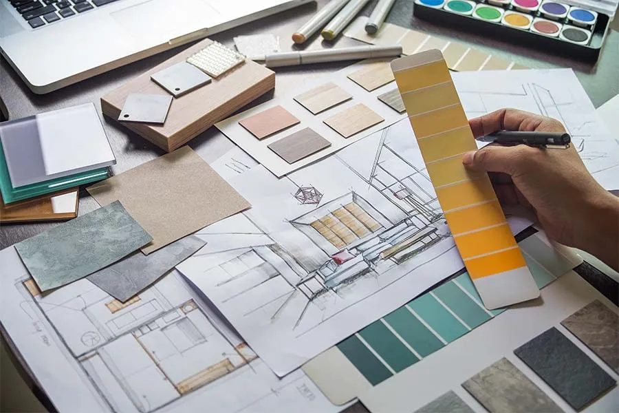 Interior sketches and color swatch books being examined on a table