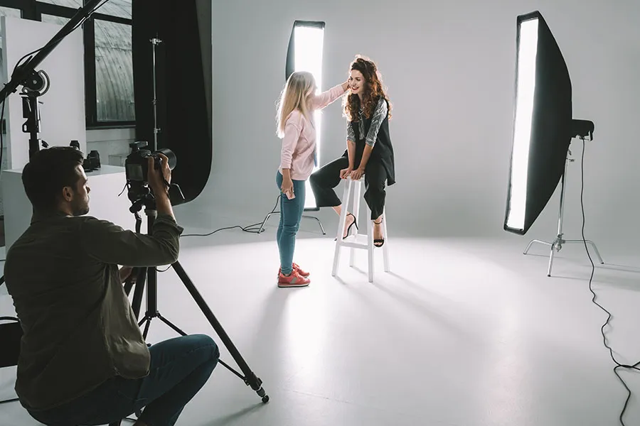 Photographer in studio coaching a model