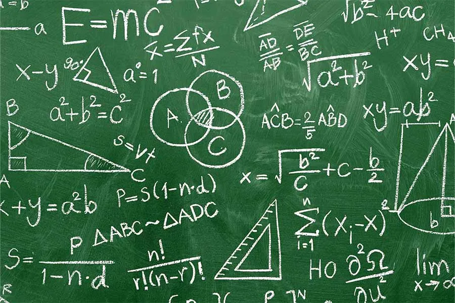 Green chalkboard covered with math equations, formulas, and geometric diagrams written in white chalk.