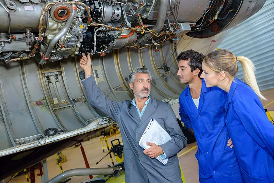 Aviation students receiving instruction on an airplane engine