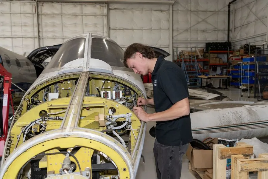 An aviation student checks the engine on a small plane