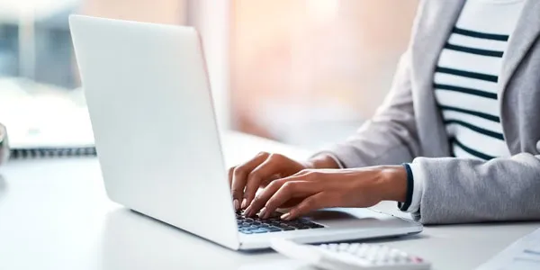 Person typing on a laptop at a desk.