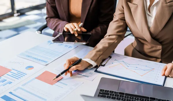 Two people reviewing documents on clipboards at a desk