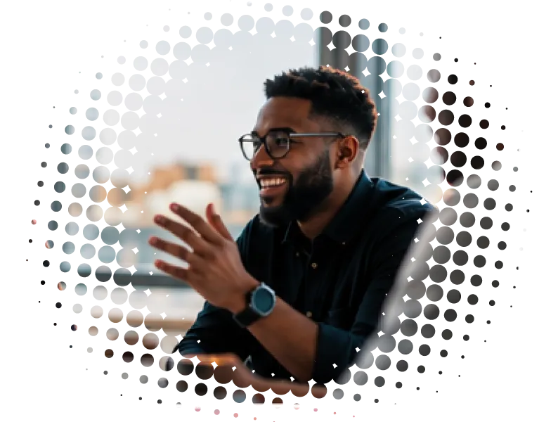 African-American man smiles while talking to someone not shown.