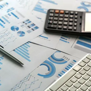 Business reports with charts, calculator, pen, and keyboard