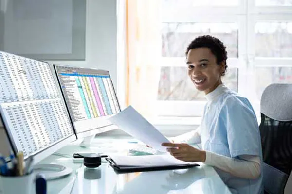 man seated at computer smiling