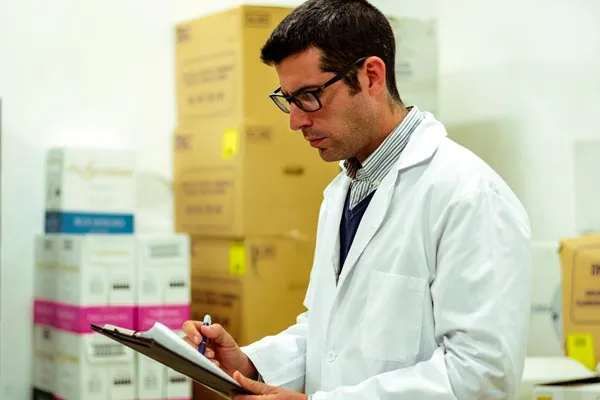 man in white coat looking at clipboard