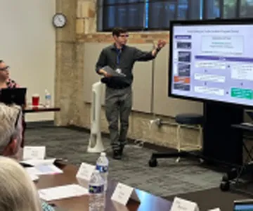 A facilitator points to a board while compression planning participants look on