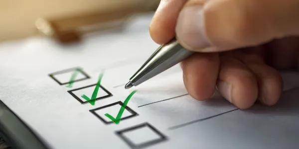 Closeup of a person marking a checklist complete