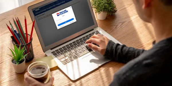Person using a laptop to register for a Dallas College form