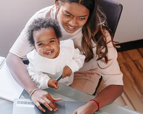 A mother student taking classes online with Dallas College to care for her baby at home