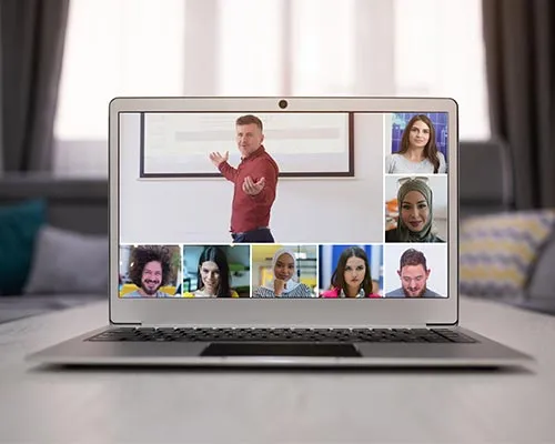 A laptop showing a video call with college professor and students for online classes