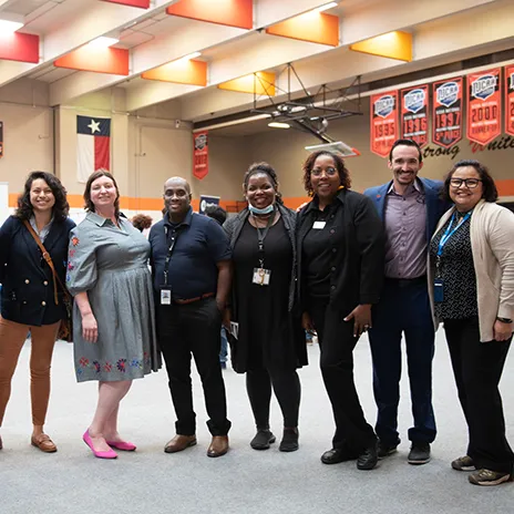 A group of employees pose for a photo in the Cedar Valley gym