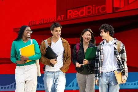 four smiling students standing in front of The Shops at RedBird