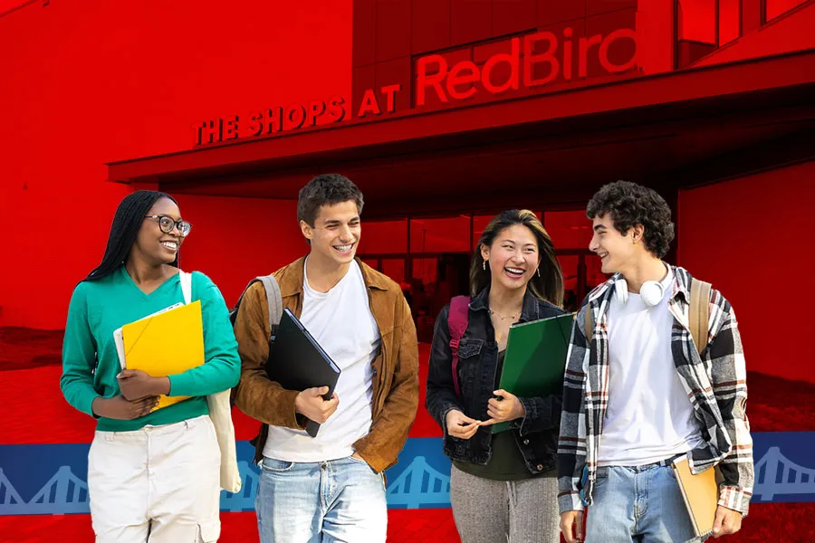 four smiling students standing in front of The Shops at RedBird
