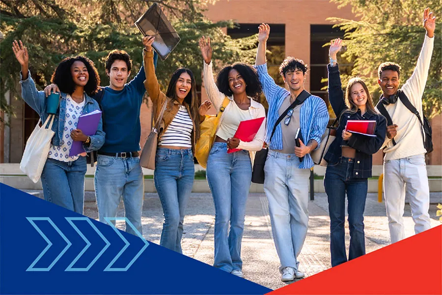a group of smiling students outside, on campus, each with one arm raised