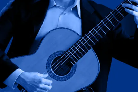 close-up of a man in a button-down shirt and a jacket playing a guitar