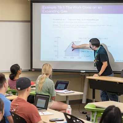 students in class with the college professor teaching