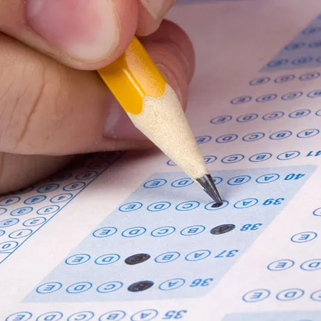 Close up view of filling out a scantron with a pencil