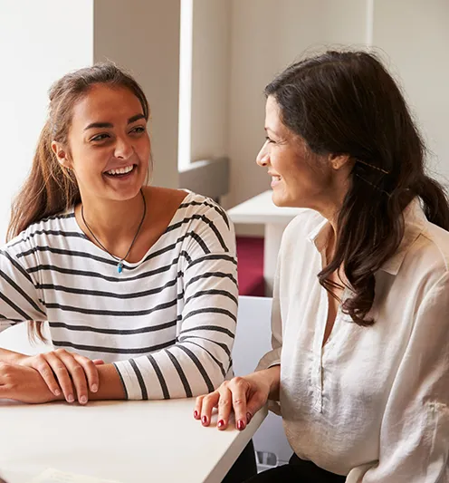female student sitting and smiling with her mother