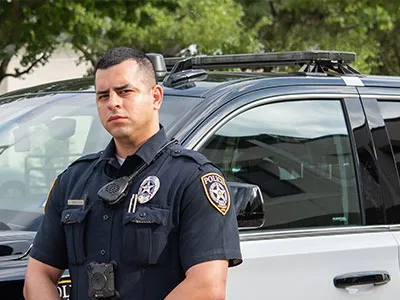 A police officer stands in front of a car