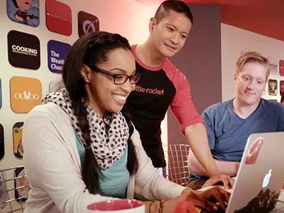 Three students at a laptop