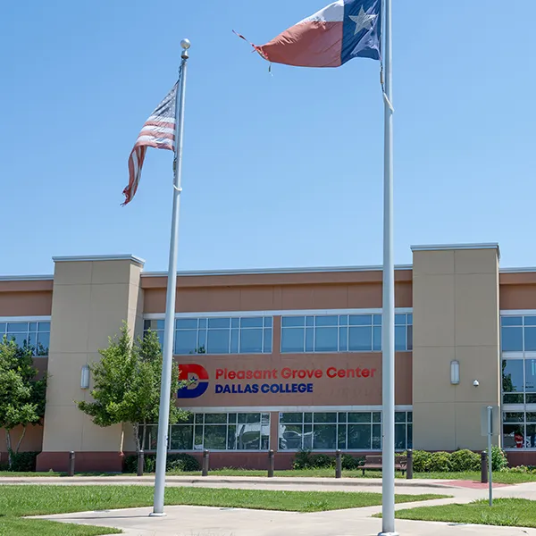 An American and Texas flag fly on flagpoles outside the entrance to the Pleasant Grove Center