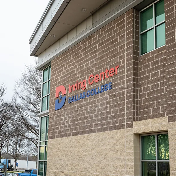 The facade of the Irving Center with a Dallas College sign on the red brick