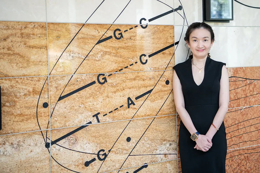 Mai Huynh standing next to wall with diagram.
