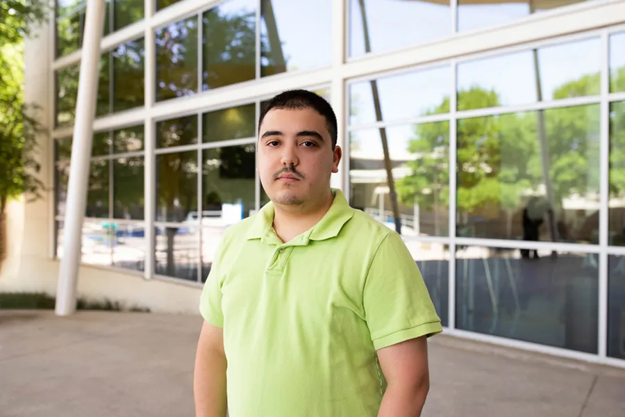 Jesus Cavazos standing in front of campus building.
