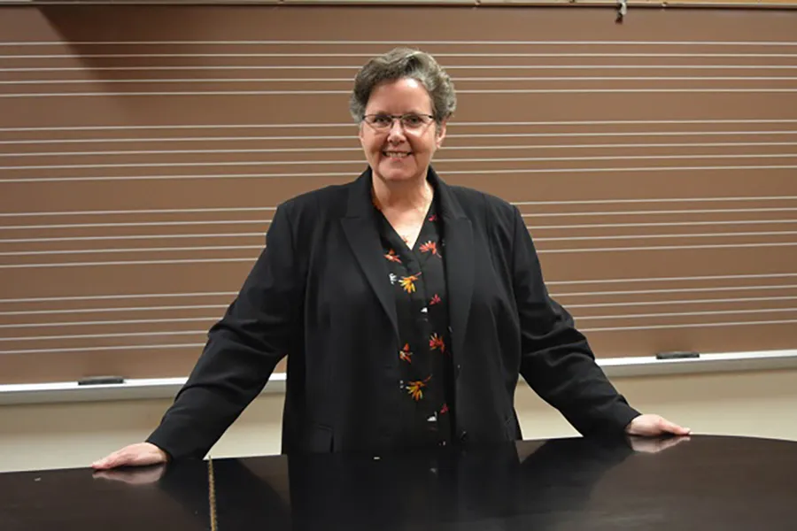 Kathryn Brownlee standing behind a piano.