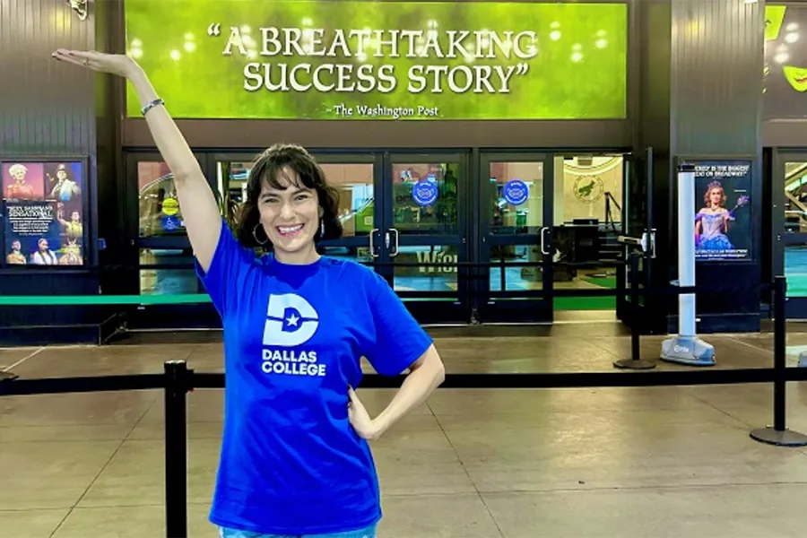 Alyssa Fox standing in front of Broadway theater door.