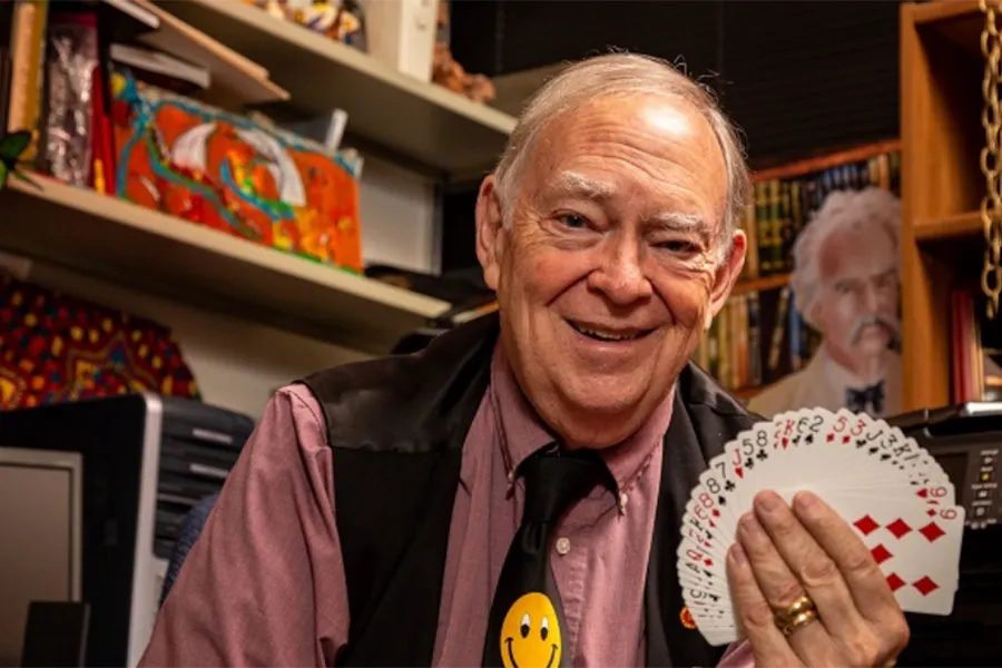 Geoffrey Grimes holding up fanned out deck of cards.