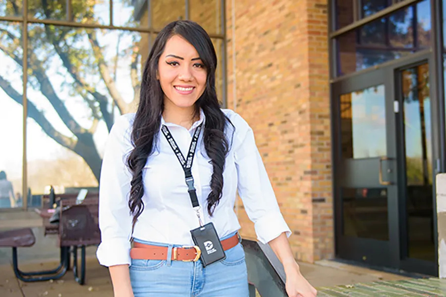 Lilian Cordero standing in front of a building on campus.