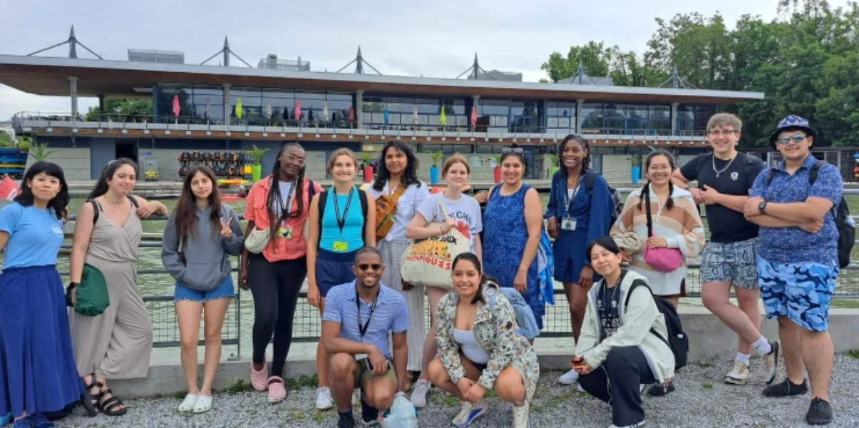 Study abroad students standing in front of a body of water and building.