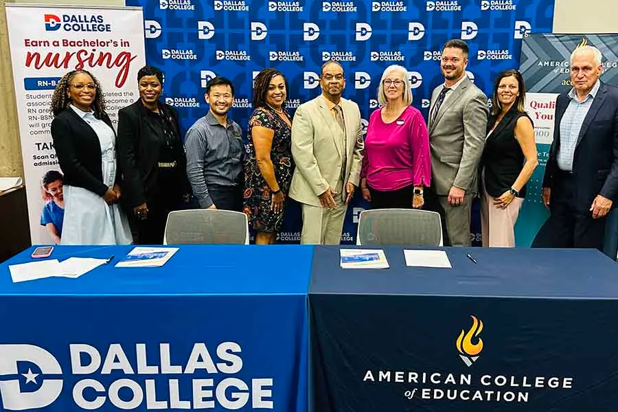 Group of officials standing behind two tables.