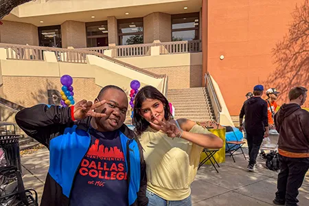 Two students pose with peace sign at campus event.