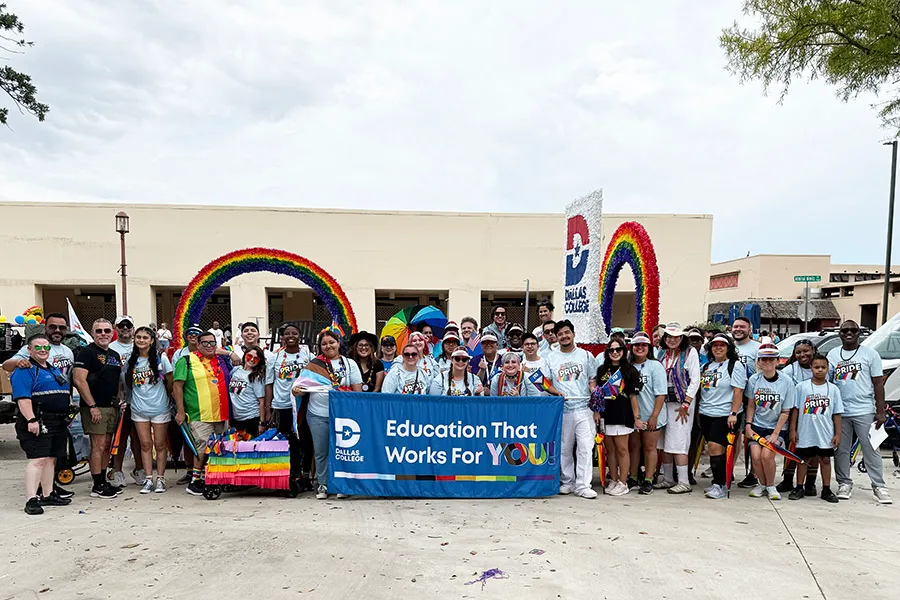 Dallas College group in front of pride float.